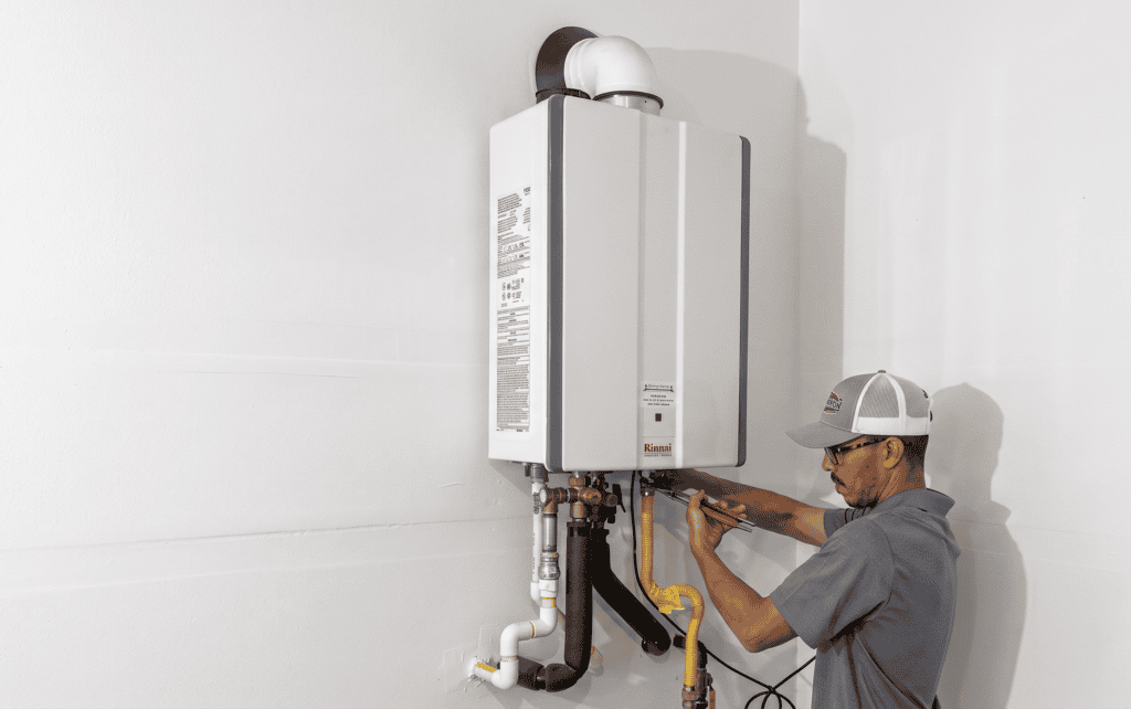 Technician repairing a water heater in a residential setting.